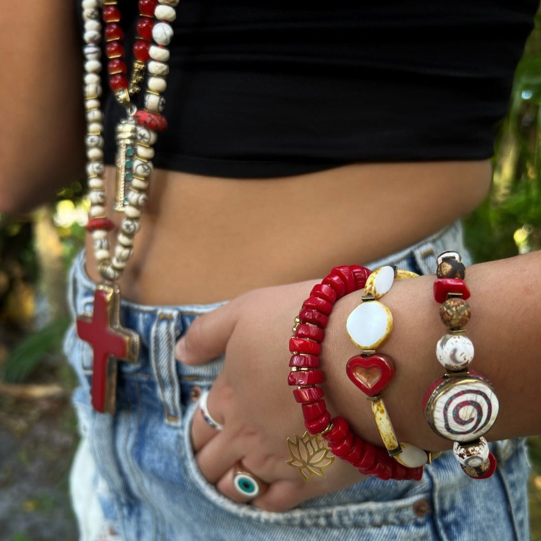 The hand model radiates tranquility while showcasing the elegance of the Yoga Spirit Mystic Bracelet, featuring coral stone beads, Nepal meditation beads, and a spiral charm with coral stone inlay.