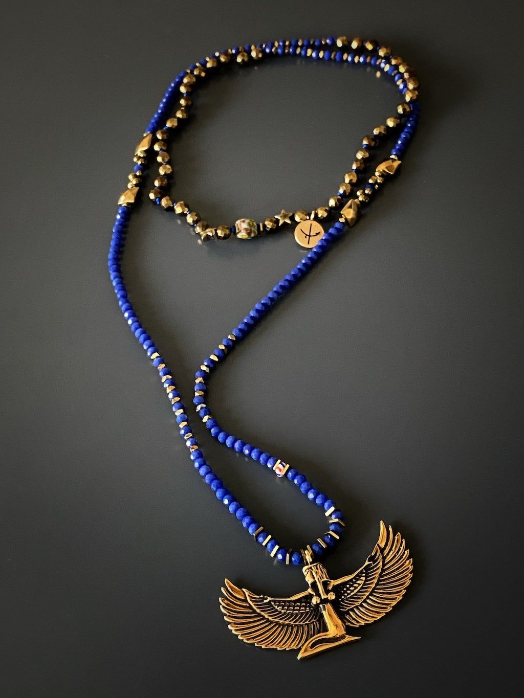 Goddess Isis Necklace featuring a bronze pendant of the Egyptian goddess and blue crystal beads, symbolizing healing and feminine power.