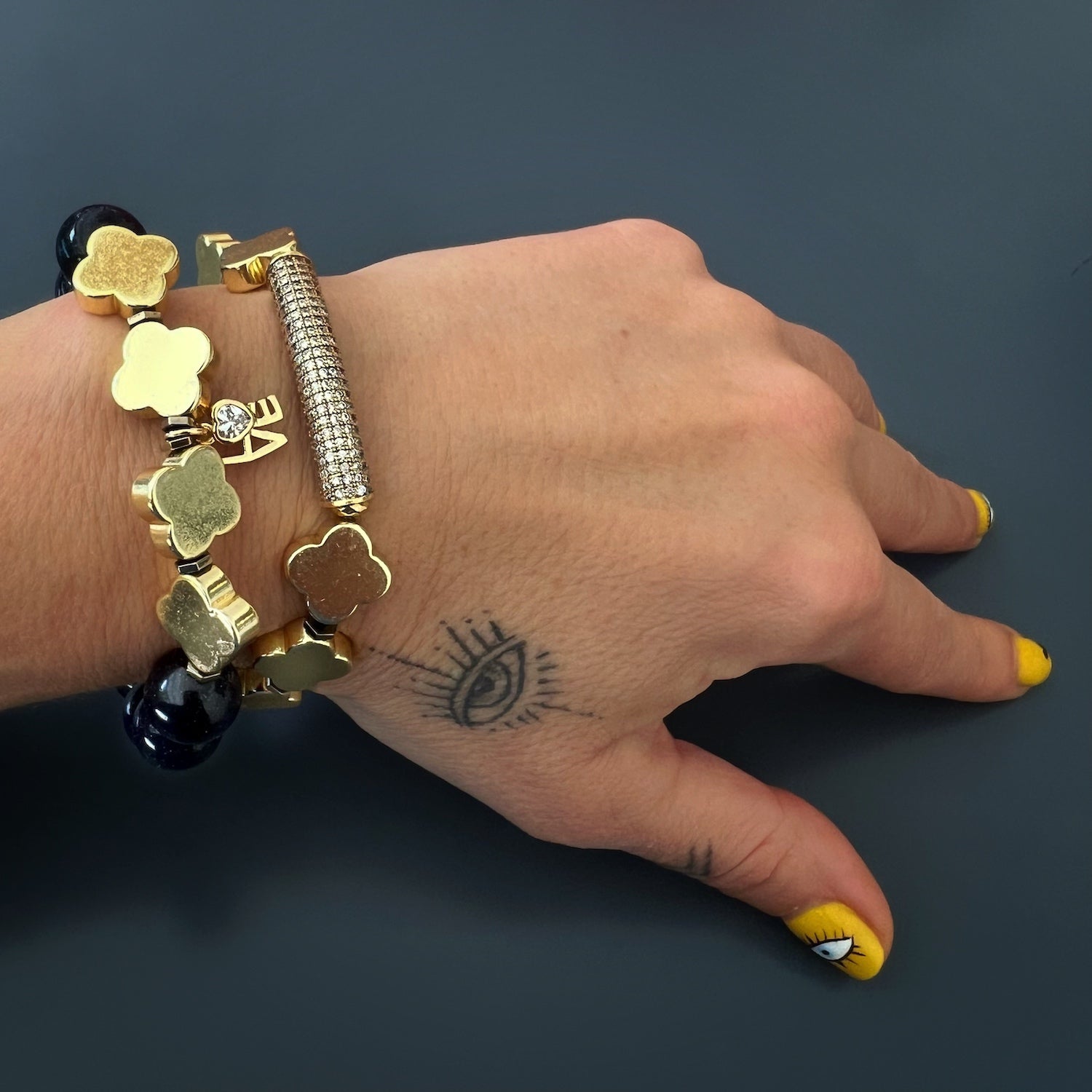 A hand model wearing the Gold Alhambra Love Bracelet, demonstrating its versatility and its ability to enhance any outfit.