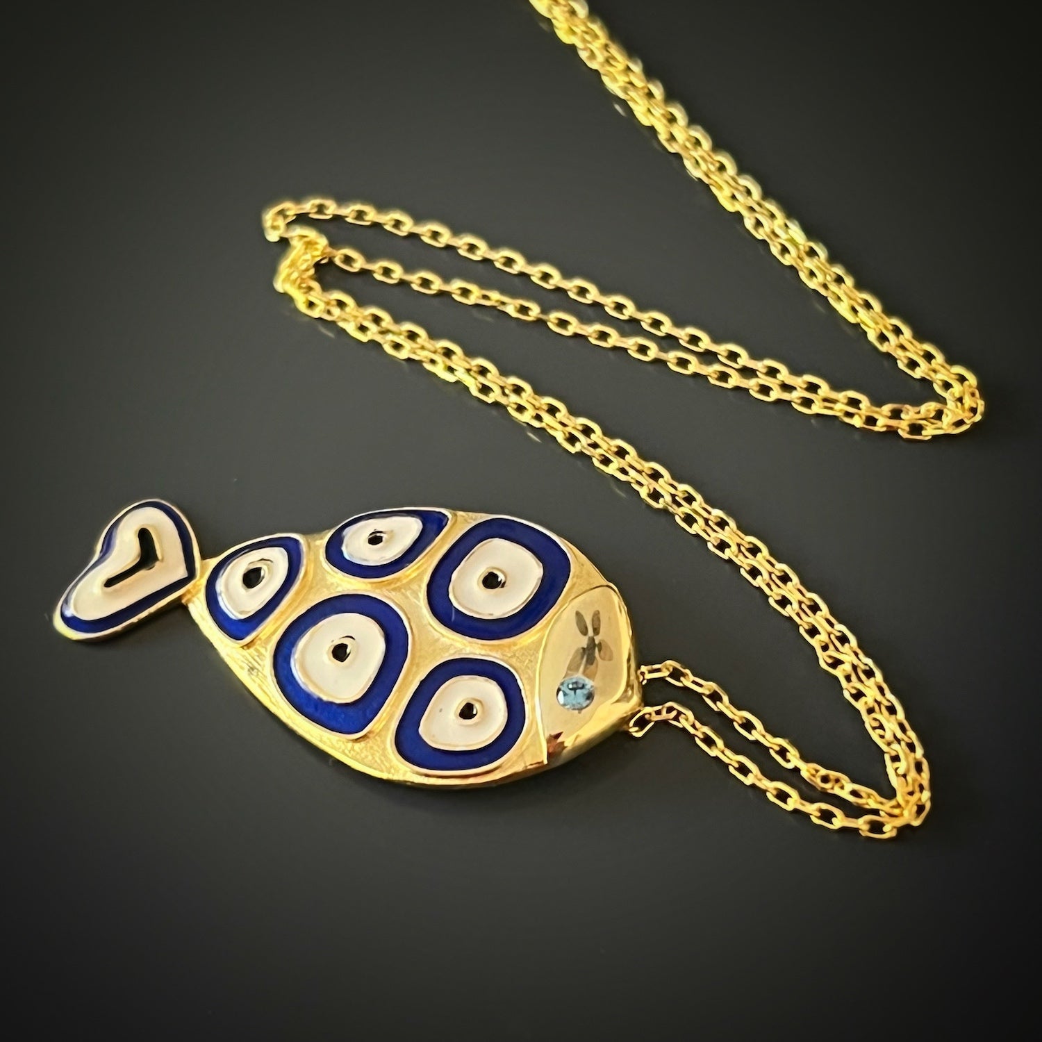 Handmade Gold and Blue Necklace - Elegant necklace showcasing a 925 Sterling silver fish pendant with blue enamel, complemented by evil eye designs, representing protection and positive energy.