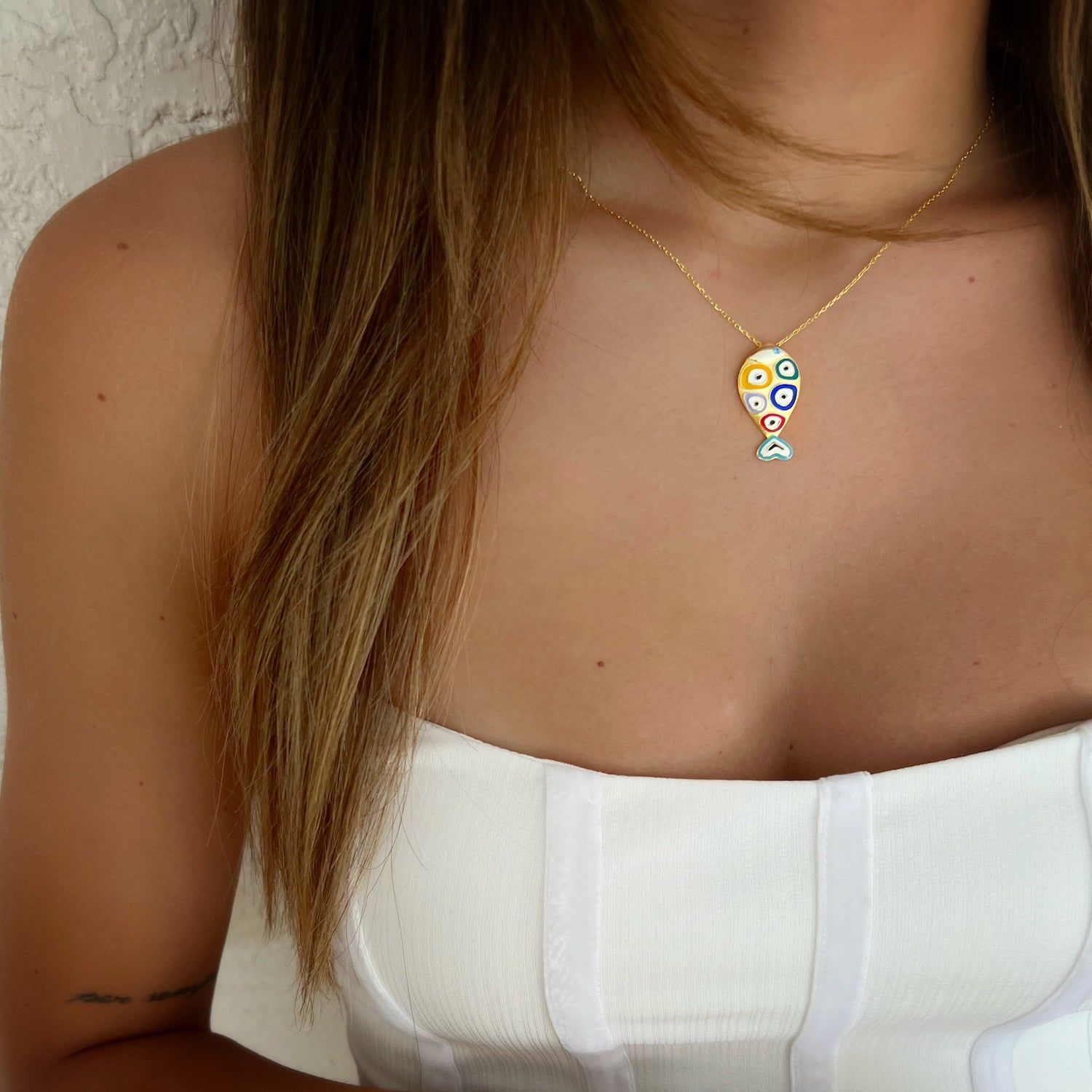 A model wearing the Gold and Blue Evil Eye Fish Necklace, demonstrating its versatility and how it adds a touch of protection and luck to everyday wear.