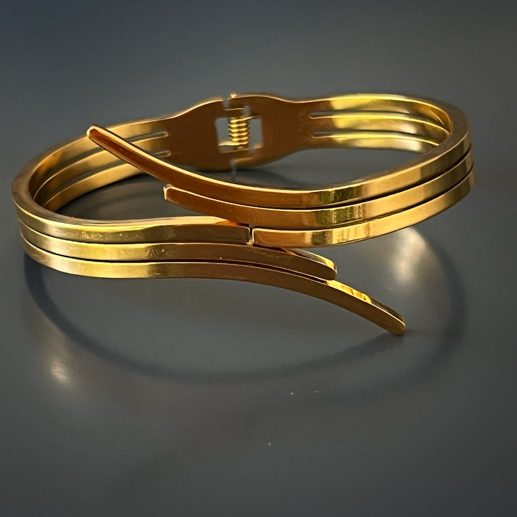 Elegant Gold Bangle Bracelet - An image featuring the gold bangle bracelet adorning a wrist, highlighting its contemporary aesthetics and smooth surface. The bracelet adds a touch of glamour to any outfit.