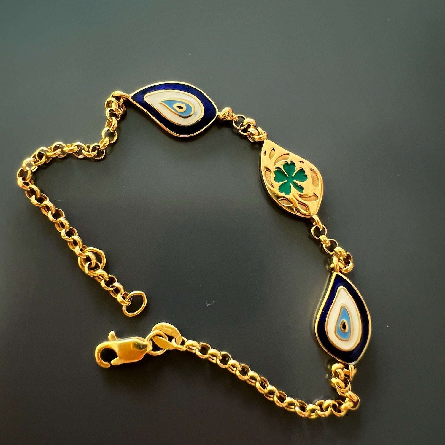 Elegant Gold Bracelet with Clover Symbol - A captivating image displaying the elegant Gold Teardrop Lucky Evil Eye Bracelet, featuring a stunning green enamel clover symbol on the back.