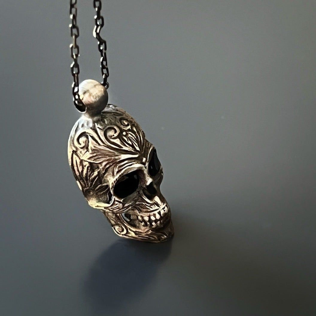 Edgy necklace showcasing a handmade sterling silver skull pendant with dark Swarovski crystals