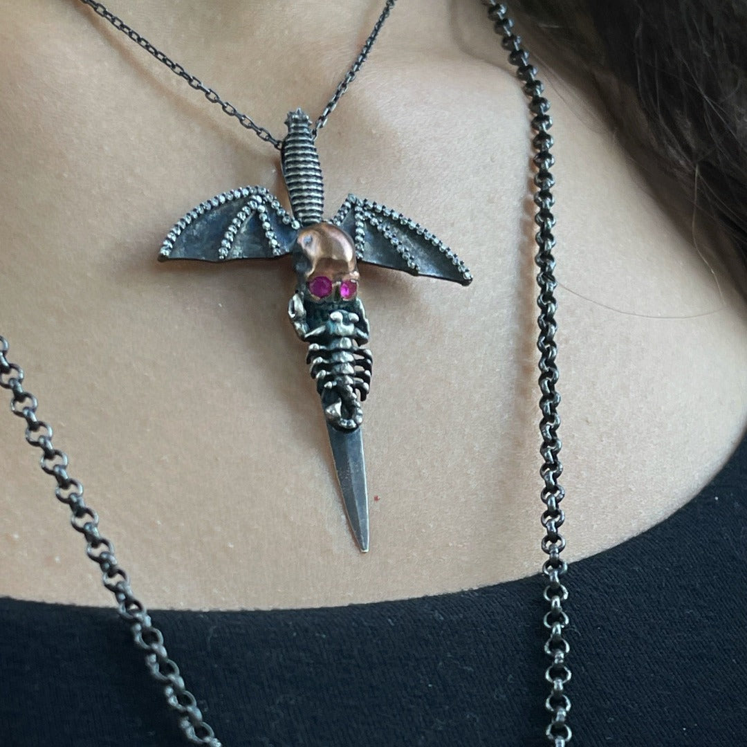 Our model showcases the Handmade Silver Skull Necklace, highlighting its edgy and unconventional design, while capturing the attention with its intricate details and captivating ruby eyes.
