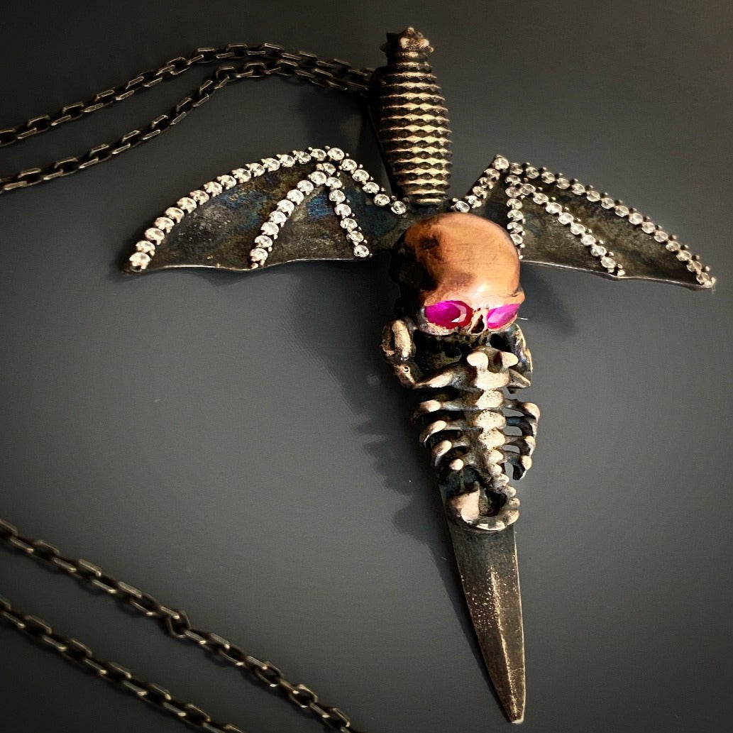 Handcrafted Silver Skull Necklace - Discover the extraordinary with this handcrafted necklace showcasing a meticulously designed silver skull pendant with intricate details, including bat wings and mesmerizing ruby eyes.