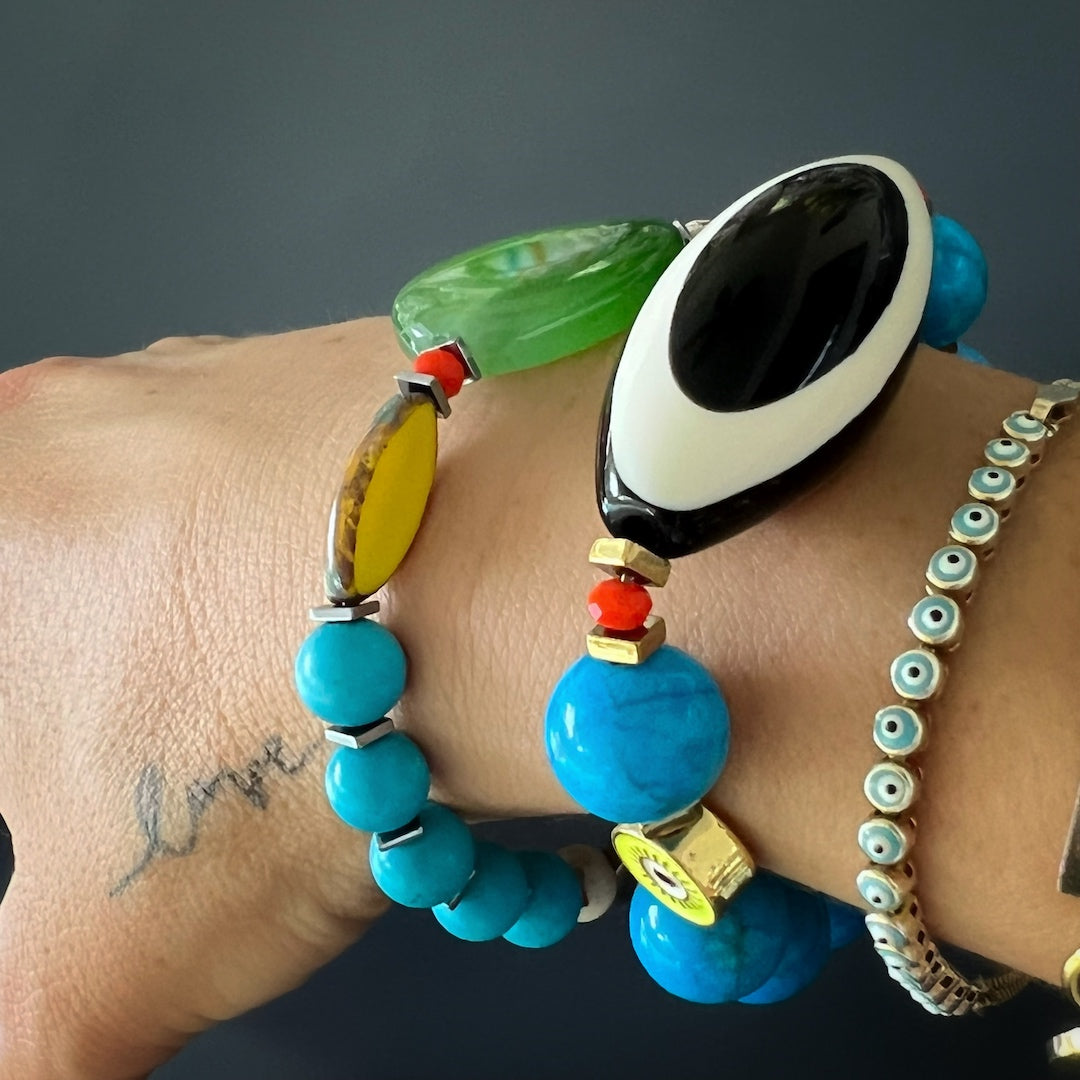 Another image of a hand model wearing the Happiness Turquoise Eye Bracelet, highlighting its unique design and the way it complements different outfits, adding a touch of luck and protection to the overall look.