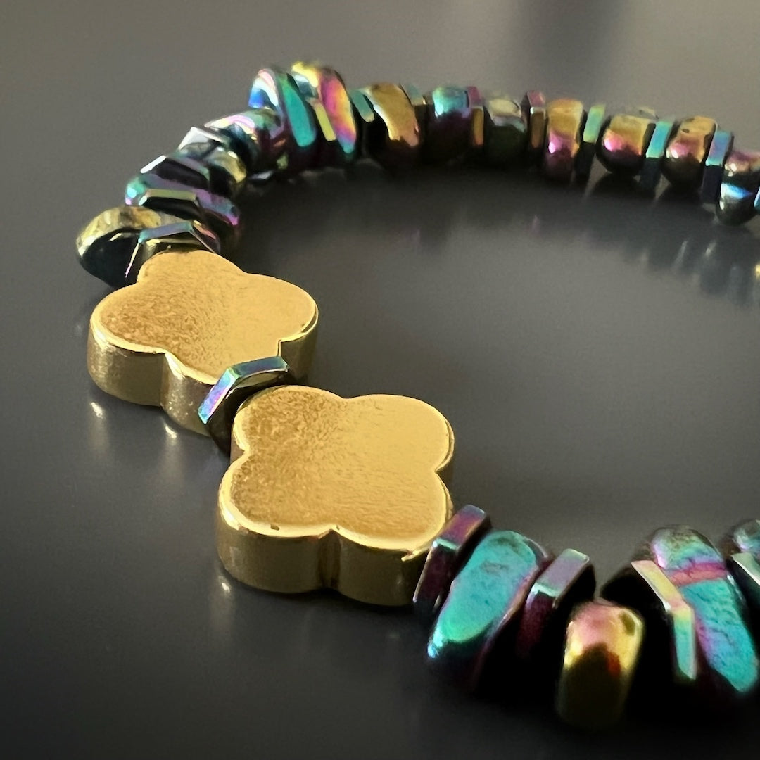 Explore the elegance of the Hematite Floral Bracelet, featuring a bronze 18K gold plated Fleur de li bead and calming Hematite stones.
