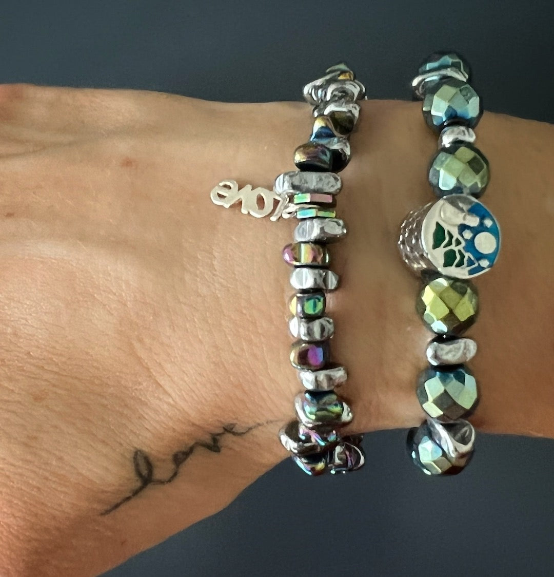 Embrace love and positivity with the Hematite Love Bracelet, beautifully worn by the hand model.