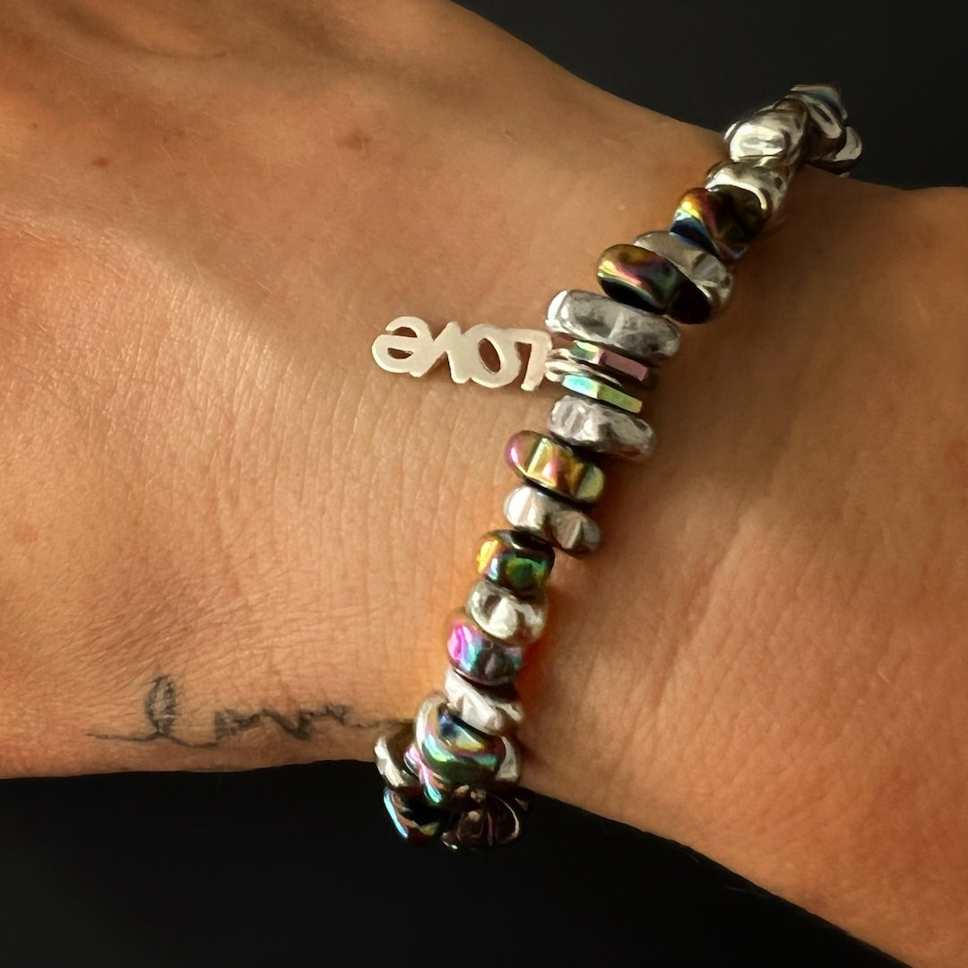 Style up your look with the Hematite Love Bracelet, as seen on the hand model.