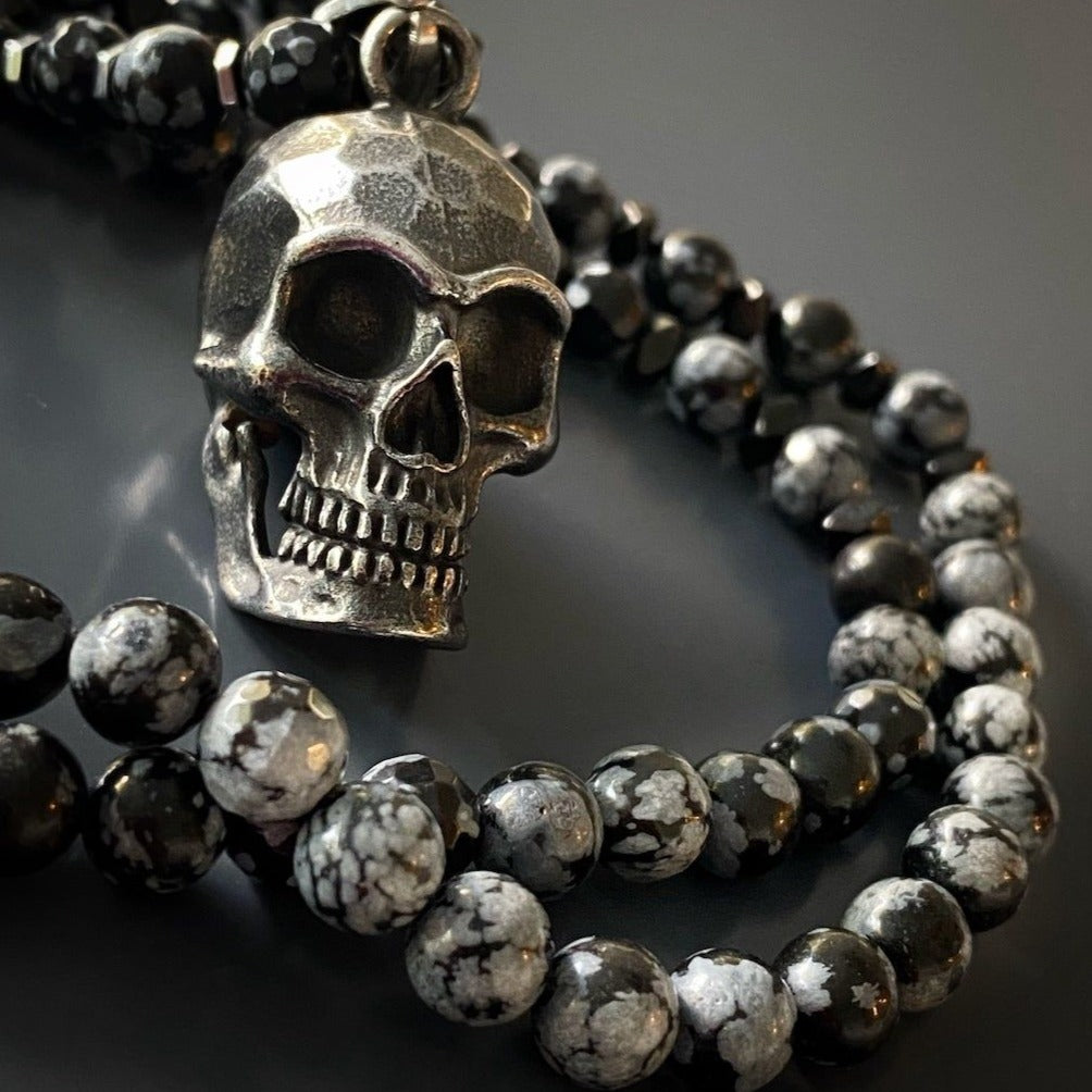 A striking necklace with Hematite and Obsidian Snowflake stone beads and a Steel Skull Pendant.