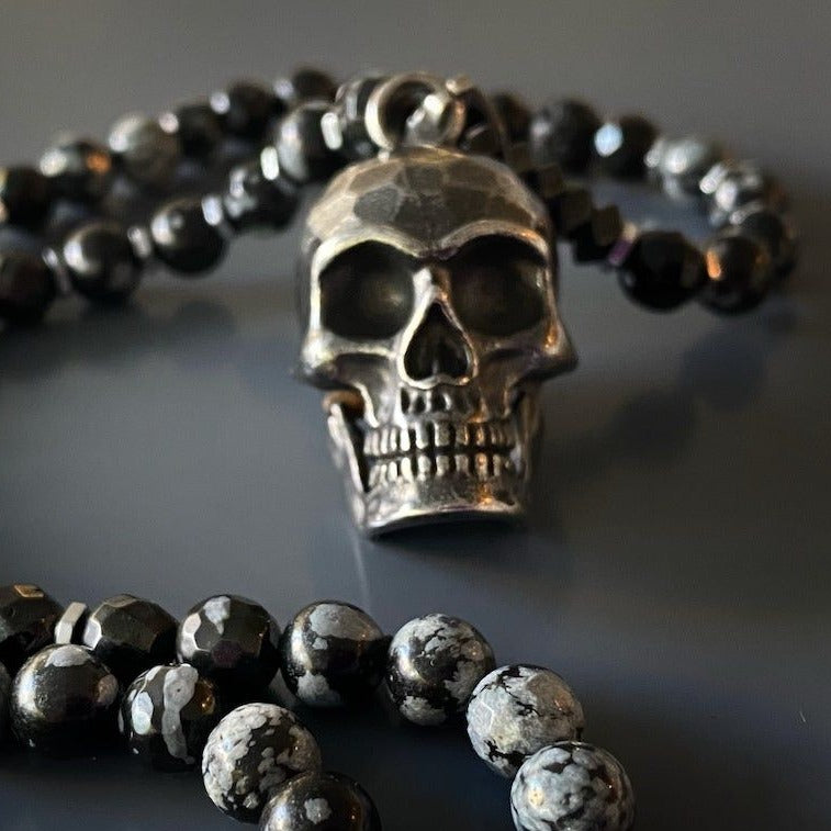 The Inner Power Skull Necklace featuring natural Hematite and Obsidian Snowflake stone beads and a meticulously crafted Steel Skull Pendant.