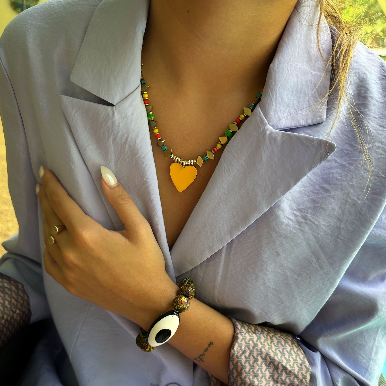 A model wearing the Joyful Heartbeat Necklace, exuding joy and confidence with its vibrant colors and heart pendant.