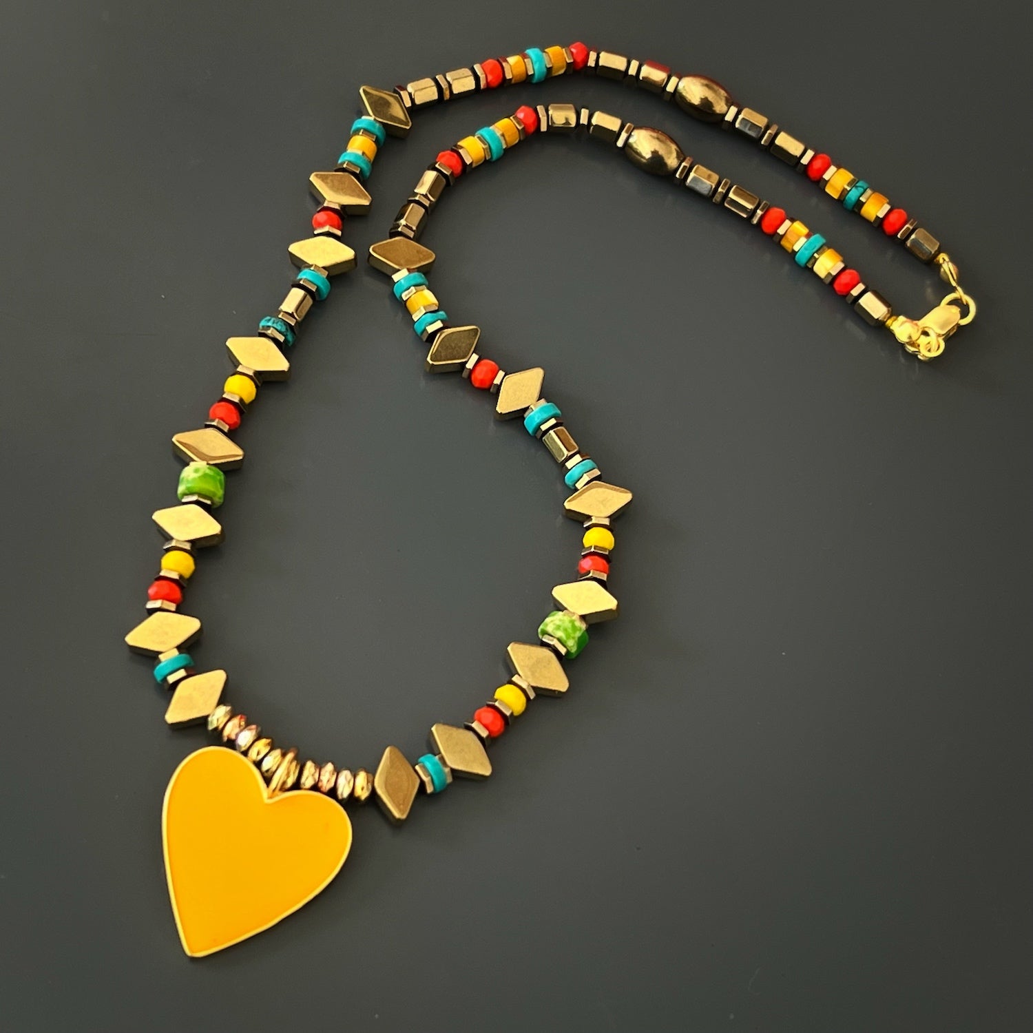 The Joyful Heartbeat Necklace, a burst of color and happiness with its vibrant beads and yellow enamel heart pendant.