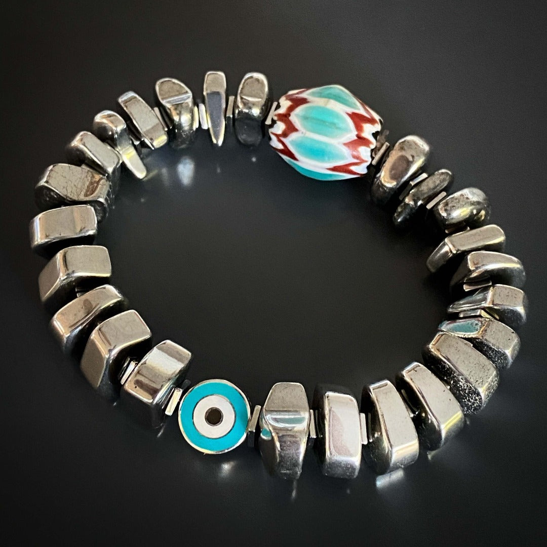 The Juno Bracelet, a unique and meaningful accessory, showcasing silver nugget hematite stone beads and a handmade Turquoise and Red Nepal bead for a touch of elegance and spiritual significance.