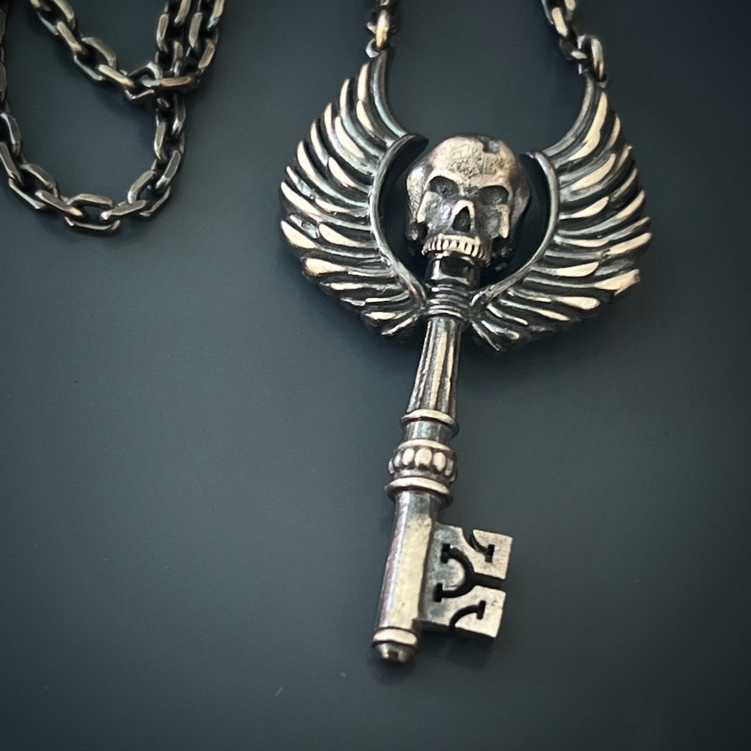 the Key Skull Silver Necklace, highlighting the unique combination of the skull and angel wings engravings on the pendant.