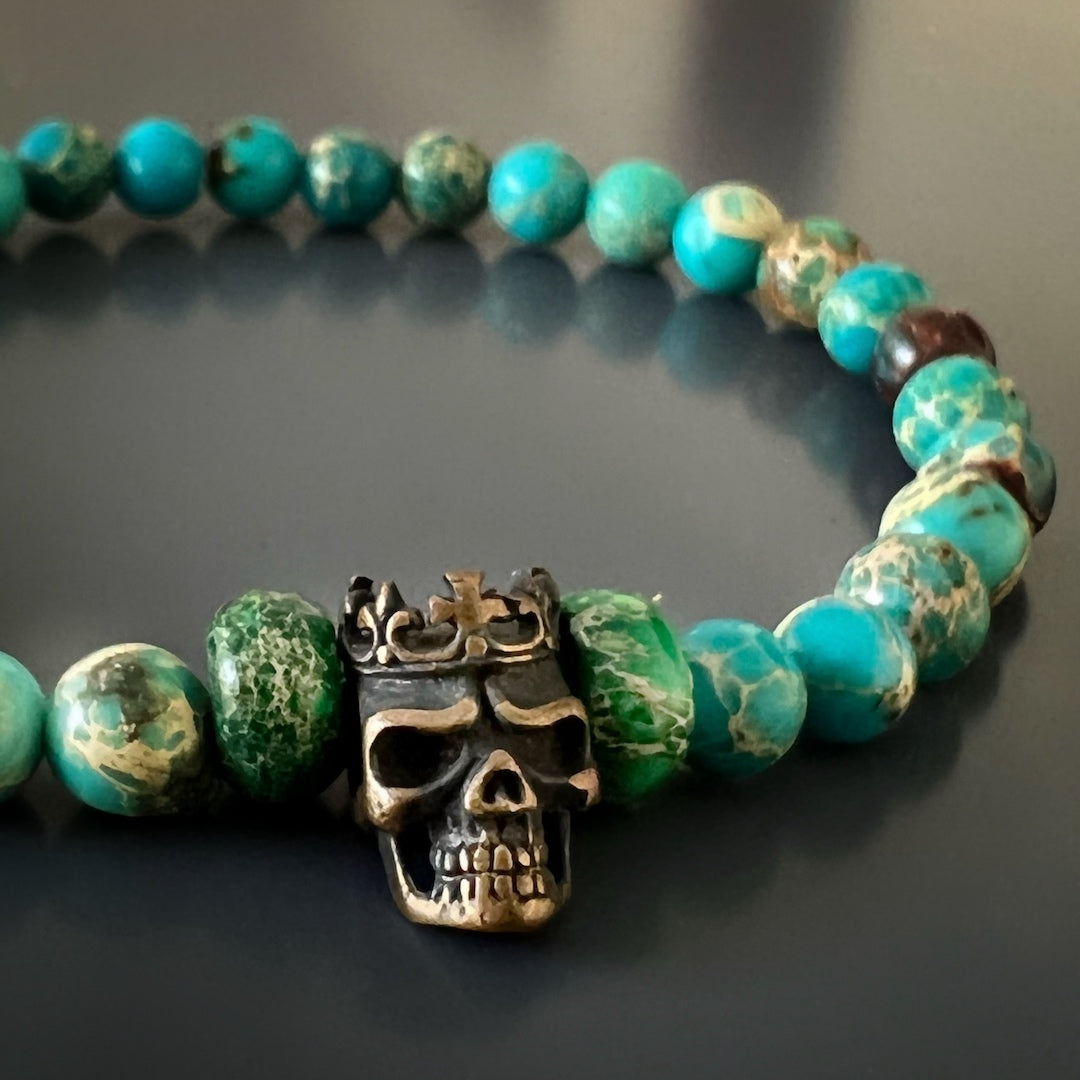 The King Skull Bracelet elegantly adorns the wrist, combining the natural beauty of the variscite stone beads with the boldness of the bronze gold-plated King Skull accent bead.