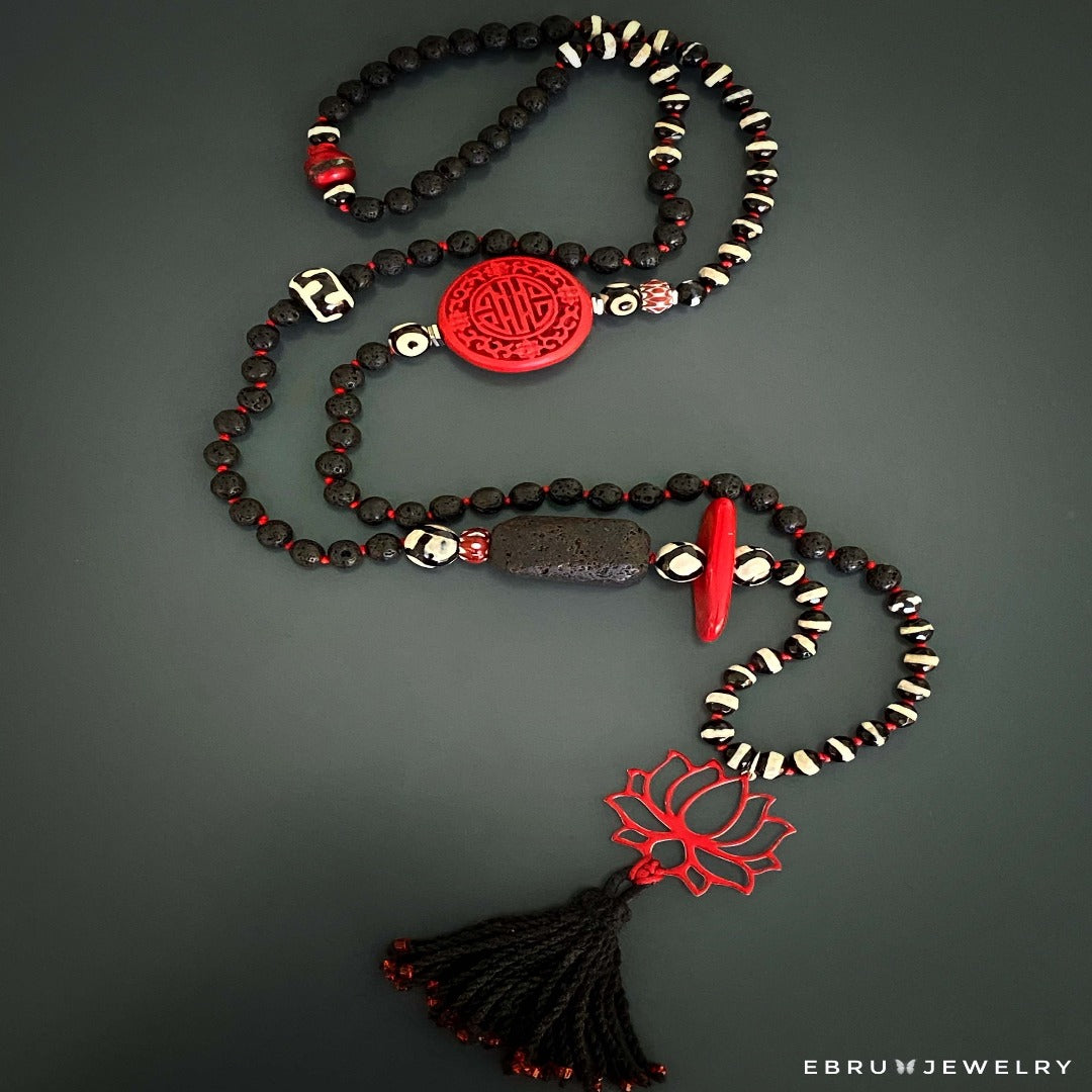 Experience the harmonious energy of the Lotus Flower Necklace, adorned with a red Nepal mantra bead and a sterling silver lotus pendant.