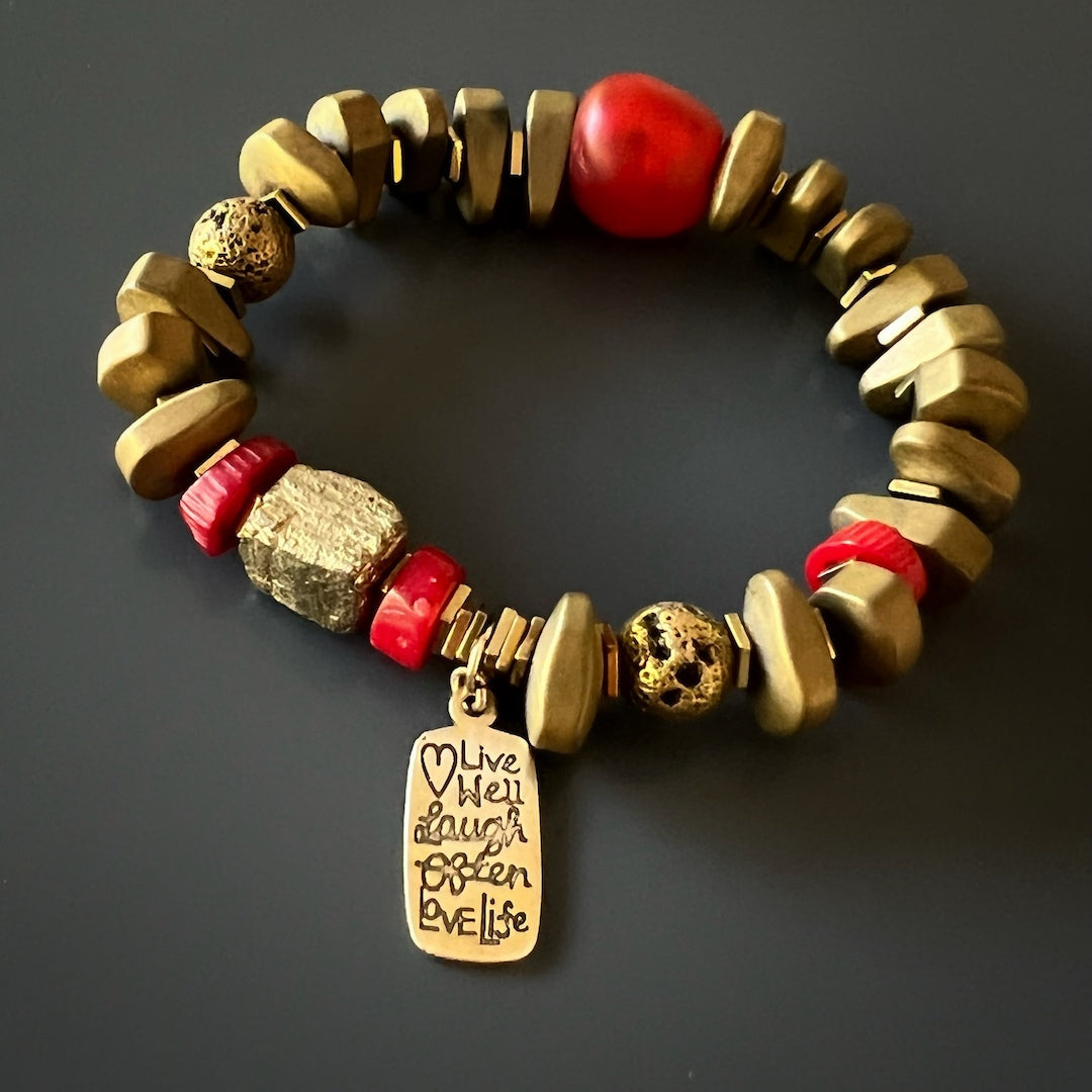 Fall in love with the vibrant pop of color in the Love Life Vintage Mantra Bracelet, showcasing red coral beads and a gold pyrite accent.