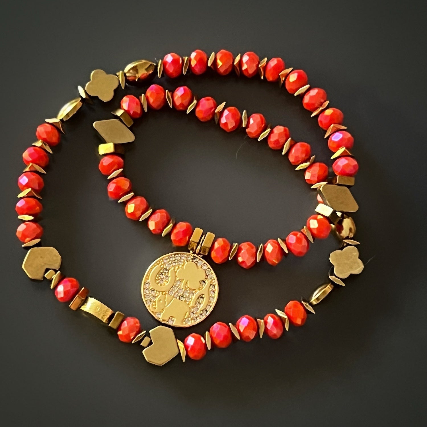 Elevate your style with the Lucky Symbol Bracelet, adorned with vibrant orange crystal beads and a gold symbol charm, a stunning and meaningful piece of jewelry.