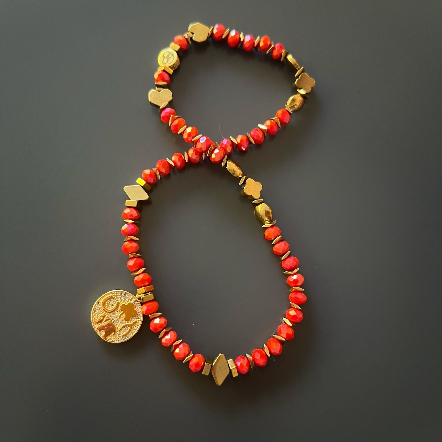 Make a statement with the Lucky Symbol Bracelet, showcasing orange crystal beads and a gold symbol charm