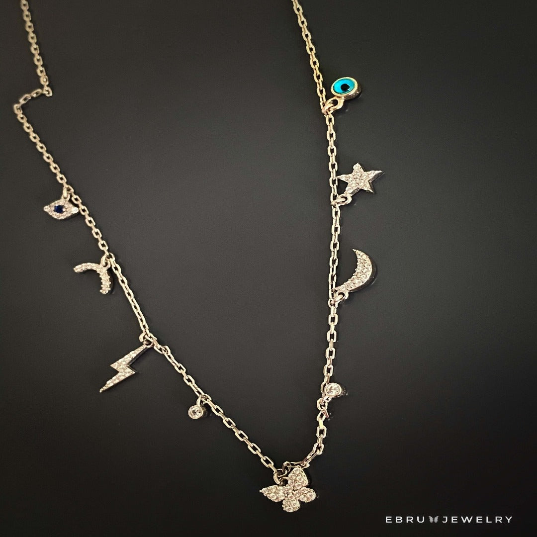 Embrace the symbolism of luck and protection with the Lucky Symbols Necklace, featuring evil eye, moon, butterfly, thunder, star, and rainbow symbols, handcrafted with 925 sterling silver.