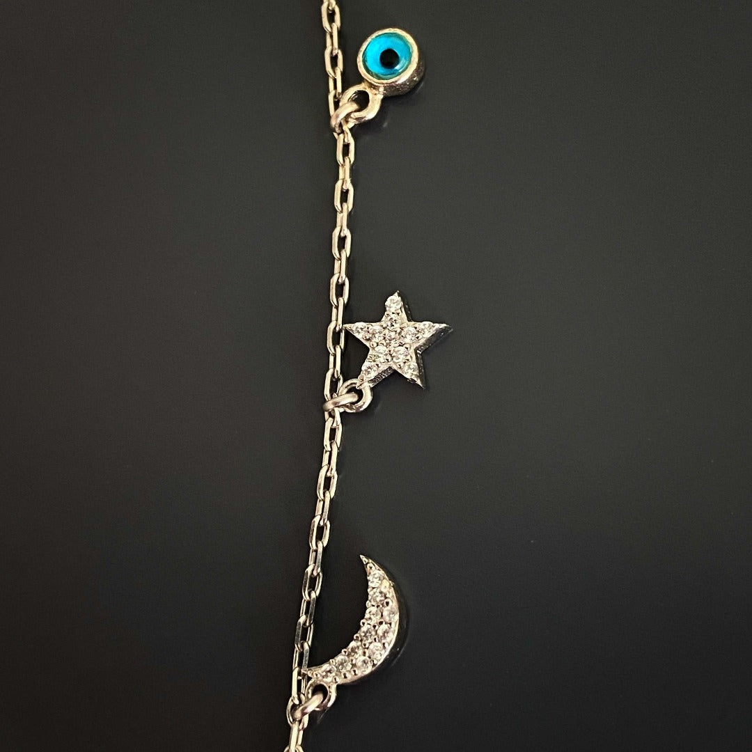 Adorn yourself with the Lucky Symbols Necklace, showcasing a collection of lucky symbols including evil eye, moon, butterfly, thunder, star, and rainbow, beautifully crafted with 925 sterling silver.