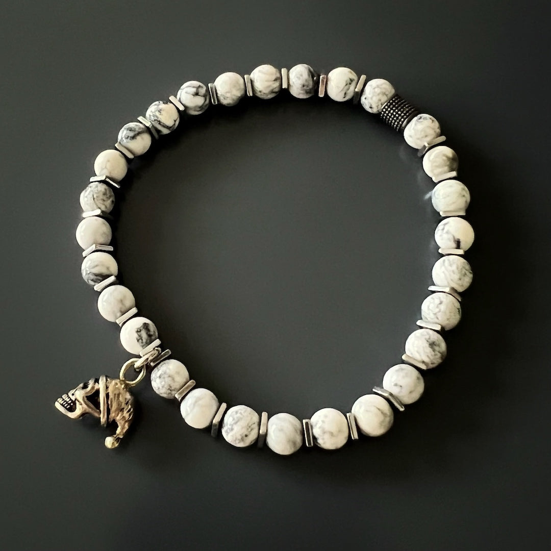 Discover the captivating design of the Men&#39;s Spiritual Beaded Skull Bracelet, adorned with a Sterling Silver skull charm and White Howlite stone beads.