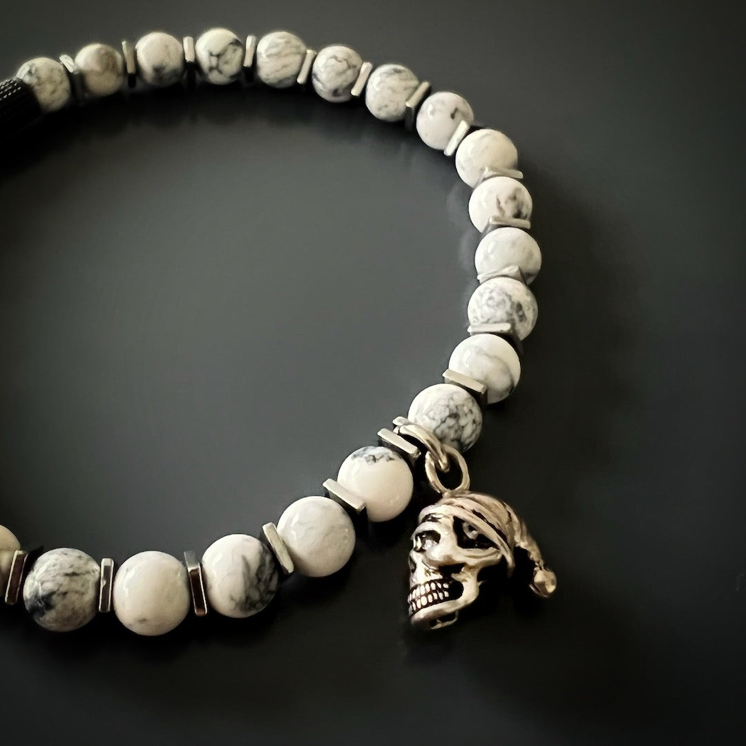 Witness the combination of spirituality and style in the Men&#39;s Spiritual Beaded Skull Bracelet, featuring a Sterling Silver skull charm and White Howlite stones.
