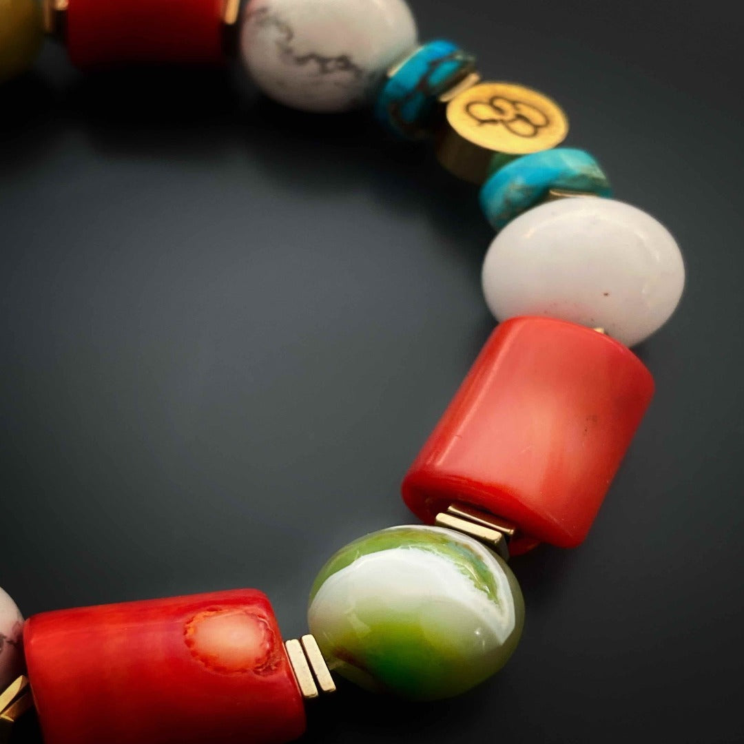 Natural turquoise stone paired with white howlite and orange coral beads in the Mila Bracelet.