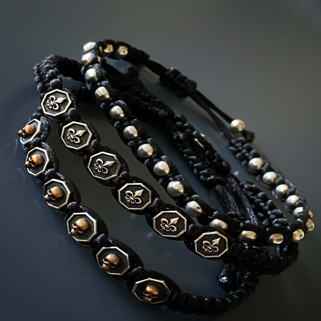 Black Skull Men Woven Bracelet featuring silver and bronze skull charms for an edgy look