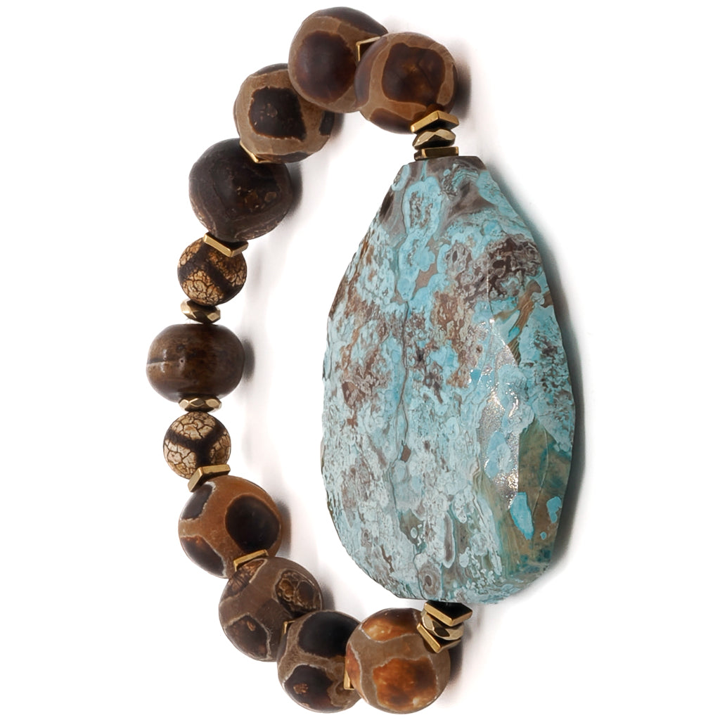 Immerse yourself in the tranquil energy of the Ocean Whisper Bracelet, featuring Tibetan Agate beads and a soothing sky blue ocean jasper stone.