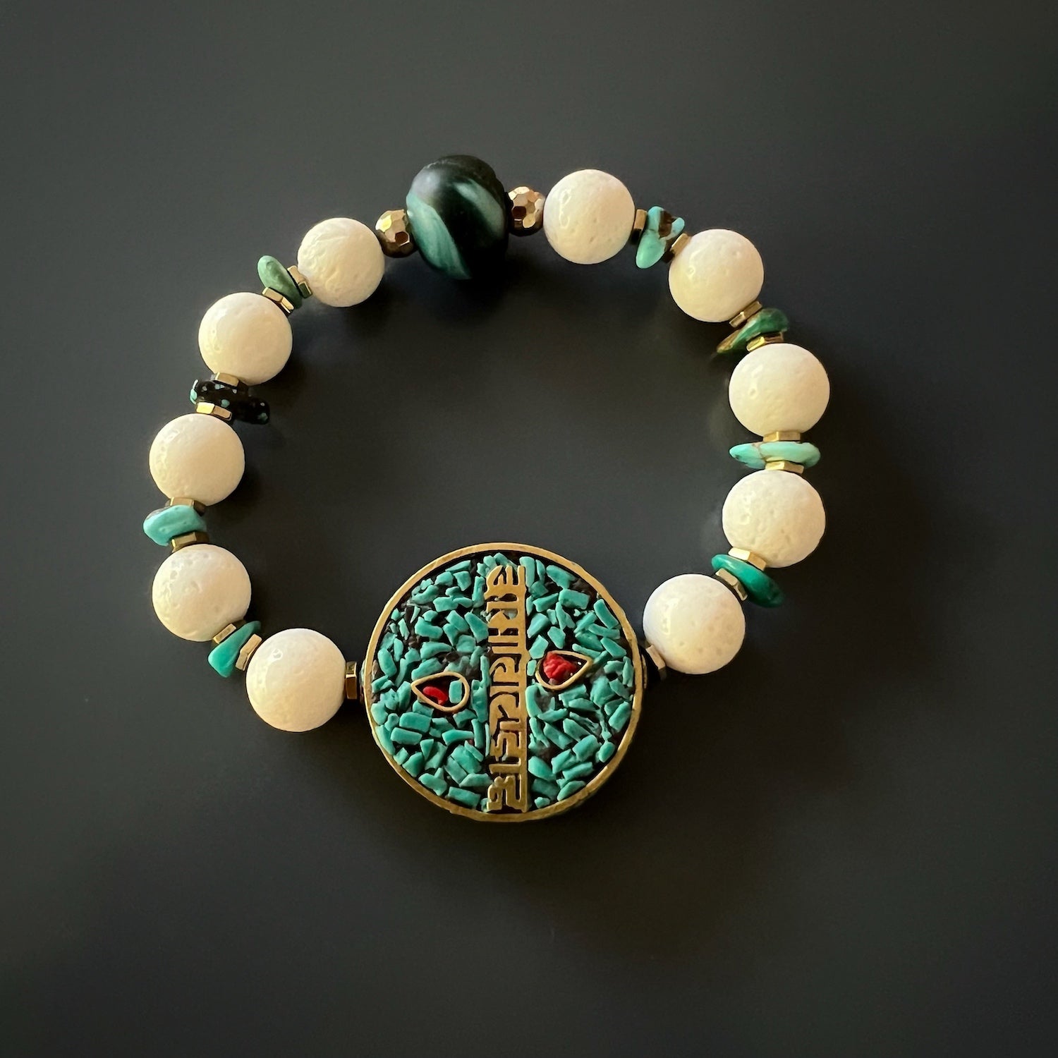 Experience the protection and good fortune of the OM Mani Mantra Bracelet, featuring turquoise and a sacred mantra bead.