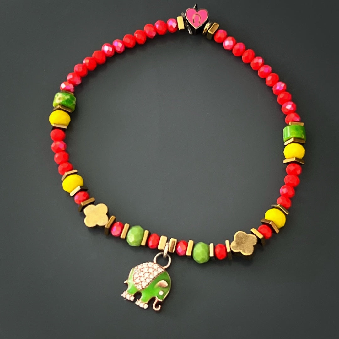 Wear the Powerful Symbol Anklet as a powerful talisman, featuring red crystal beads, green jasper beads, a gold color hematite floral bead, and silver charms of the evil eye, elephant, and lucky horse shoe for protection and positive energy.