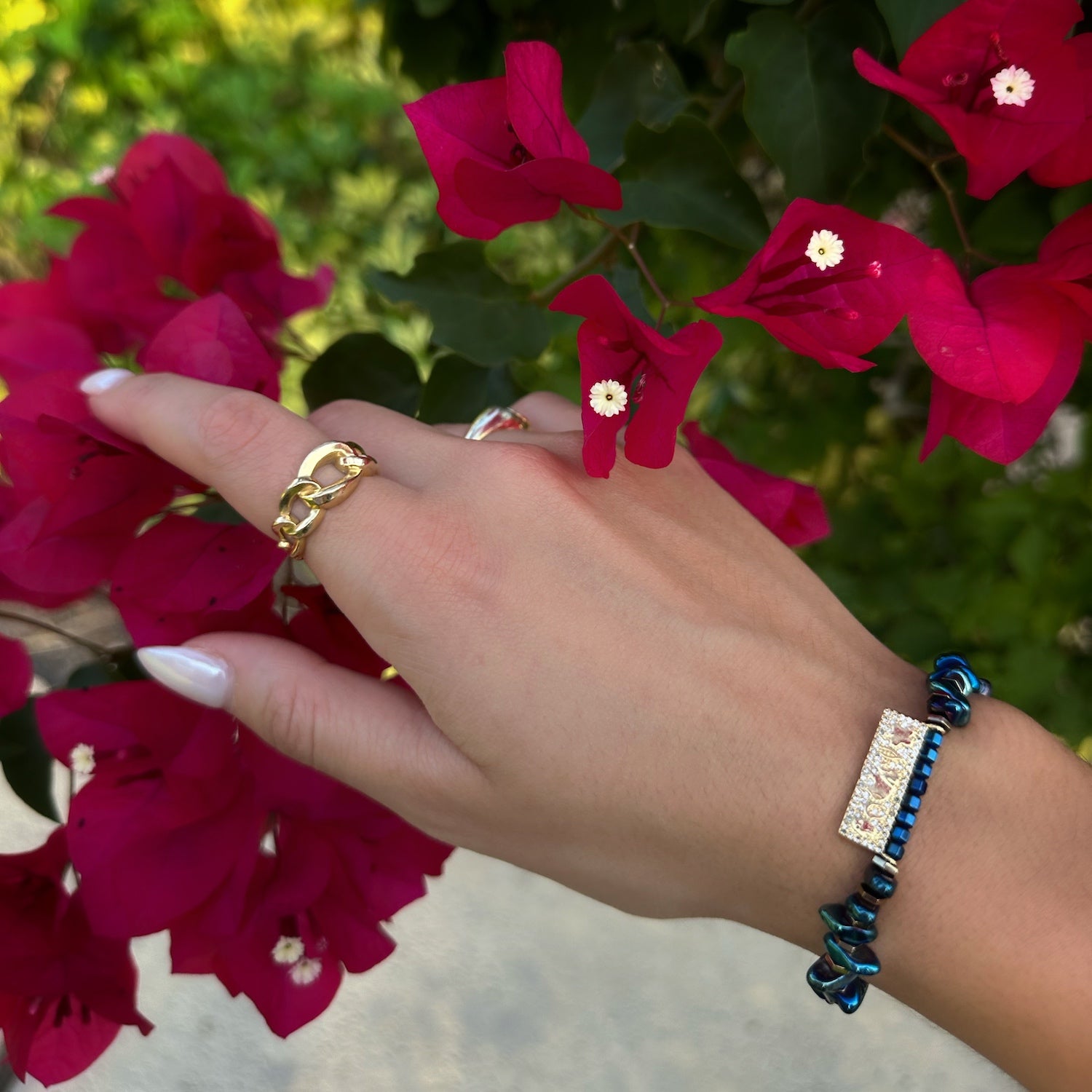 The hand model showcases the elegance and symbolism of the Protection &amp; Luck Blue Hematite Bracelet, radiating confidence and positive energy.