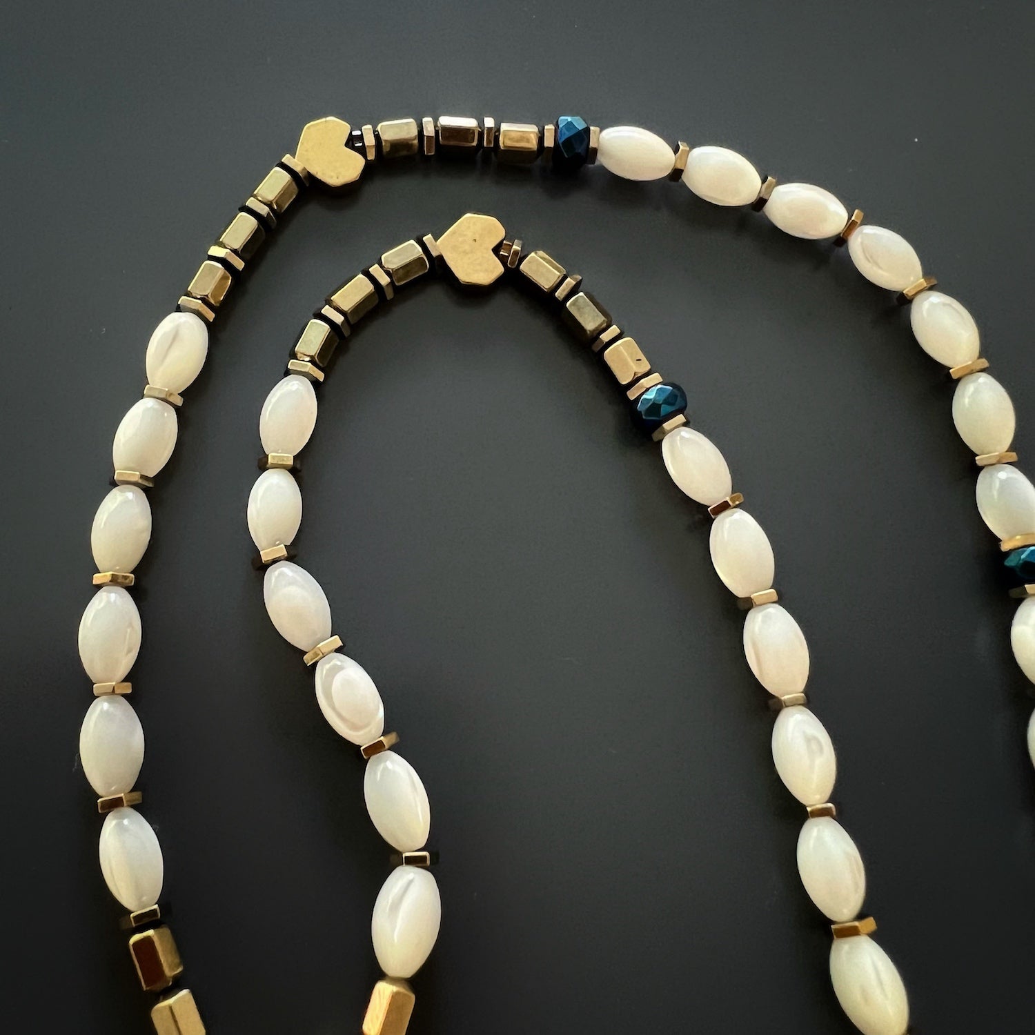 Close-up of the Mother of Pearl beads on the Pure Love Mom Necklace, showcasing their iridescent quality and natural elegance.