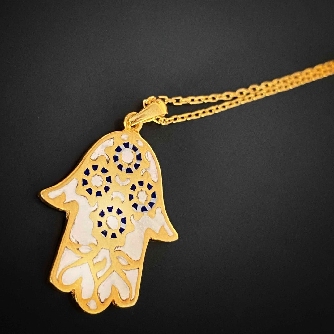 With its white enamel Hamsa pendant on an 18K gold plated chain, symbolizing pure love and positive energy.