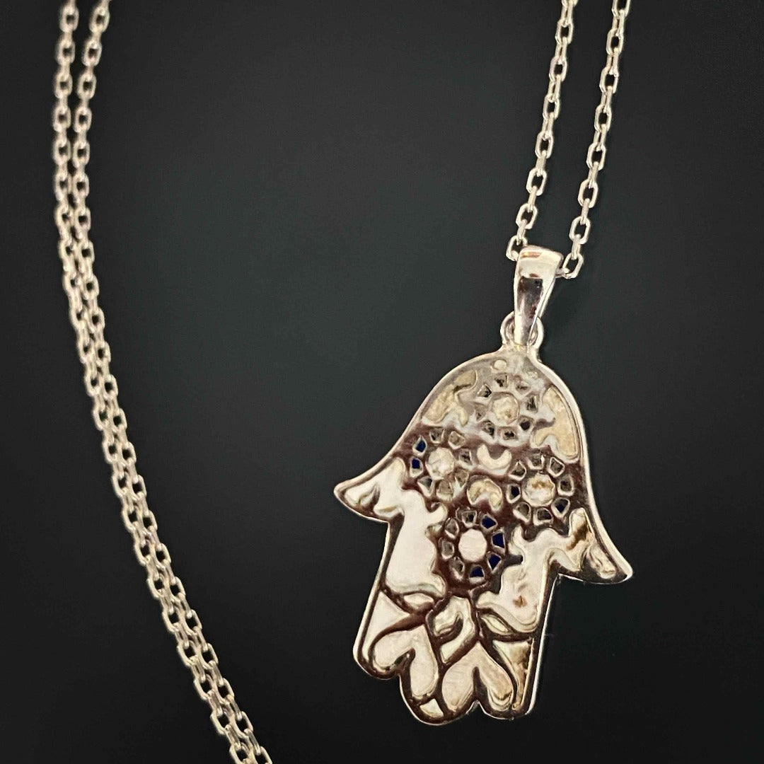The Pure Love Hamsa Necklace exudes beauty and spirituality, showcasing its white enamel Hamsa pendant on a sterling silver chain, symbolizing pure love and good fortune.
