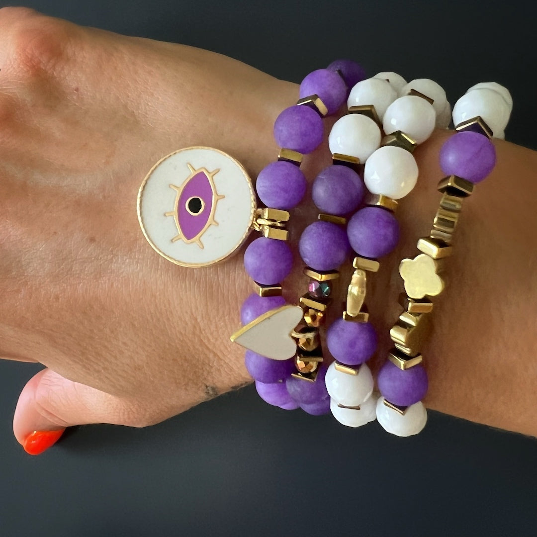 The Purple Romantic Bracelet Set complements the hand model&#39;s style, adding a vibrant pop of color and positive energy to her outfit.