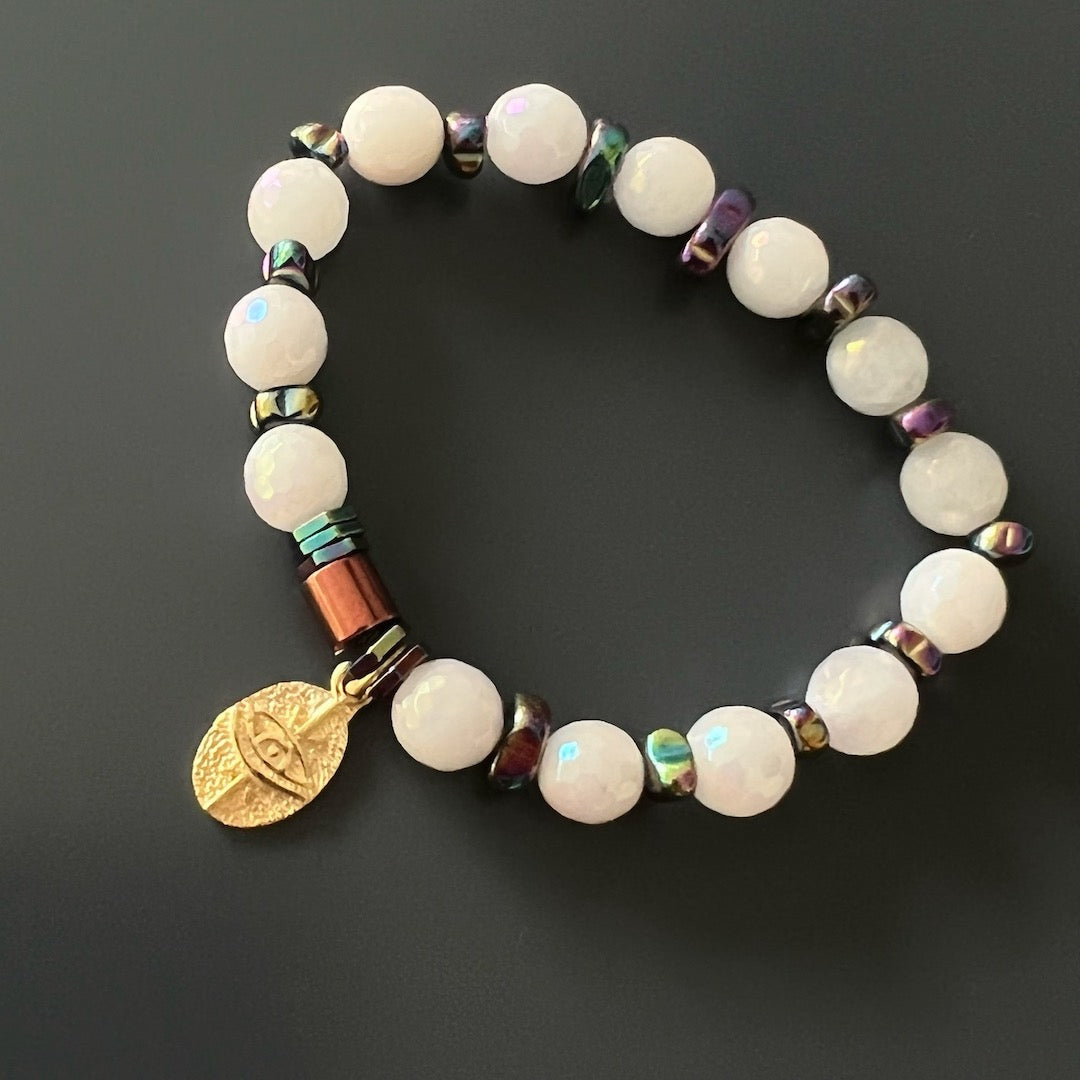 Experience the calming and protective energy of the Quartz Protection Bracelet, showcasing Rose Quartz stone beads and a 925 Sterling Silver 18K gold-plated Protection Eye charm.