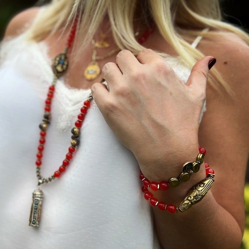 See how the Red Carnelian Vintage Bracelet enhances the hand model&#39;s style with its vibrant carnelian stone beads and intricately designed Nepal brass charm.
