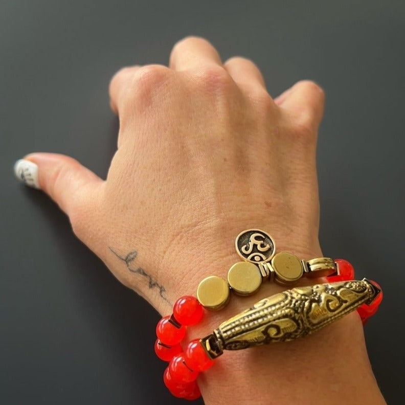The hand model showcases the elegance and vintage charm of the Red Carnelian Vintage Bracelet, adorned with carnelian stone beads and a captivating Nepal brass charm.