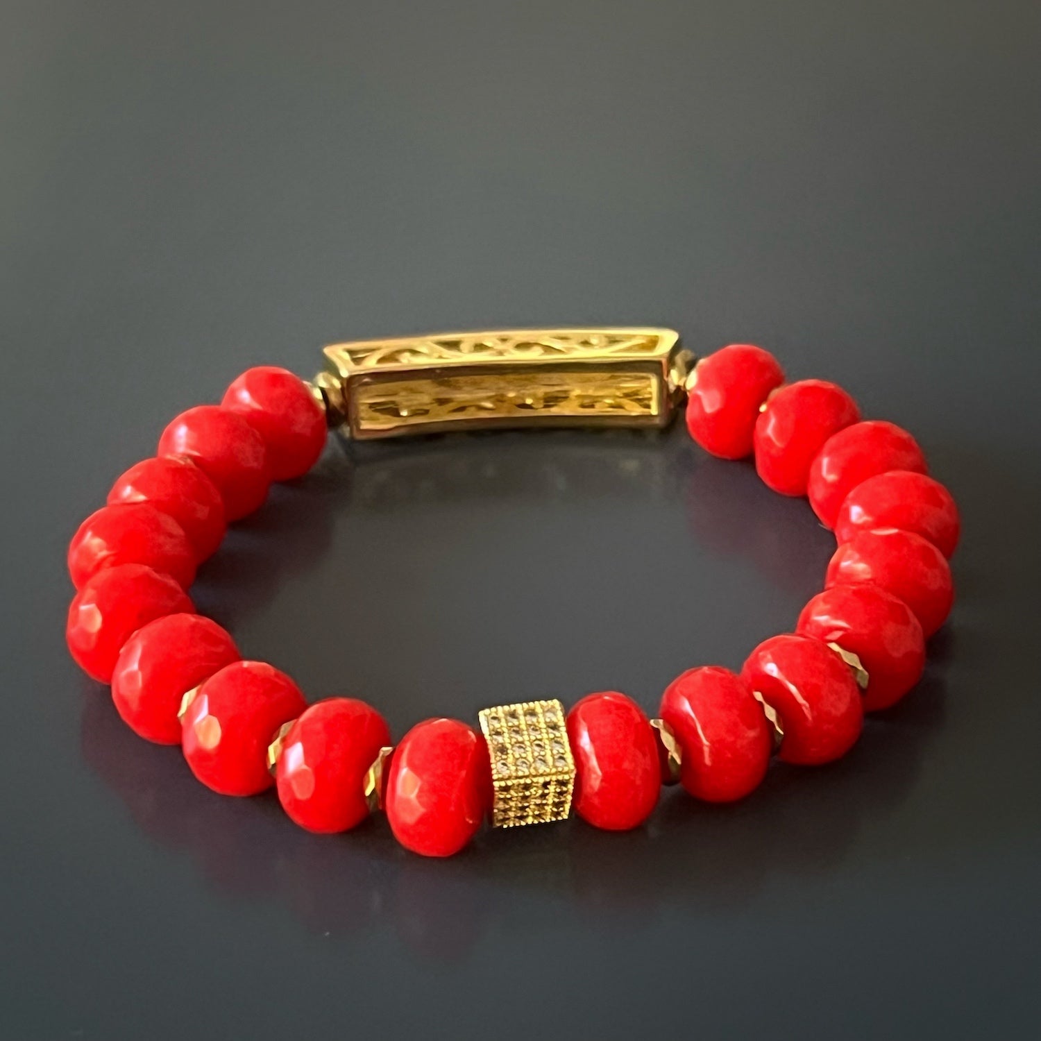 Embrace the symbolism of protection and luck with the Red Energy Evil Eye Bracelet, featuring red coral stones and a gold-plated evil eye charm.