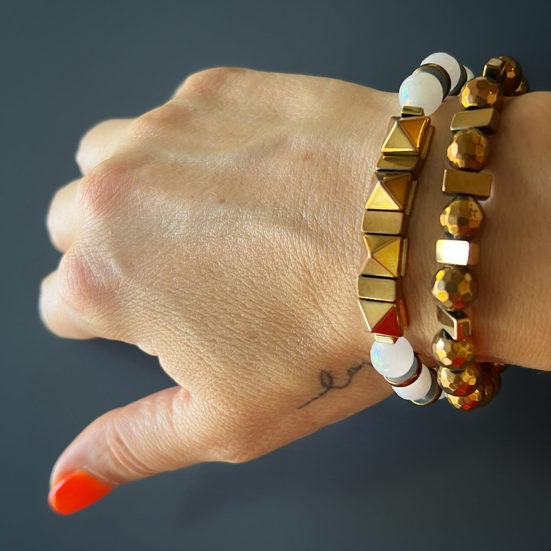 The hand model exudes elegance while wearing the Rose Energy Quartz Bracelet Set, featuring rose gold hematite and quartz stones.