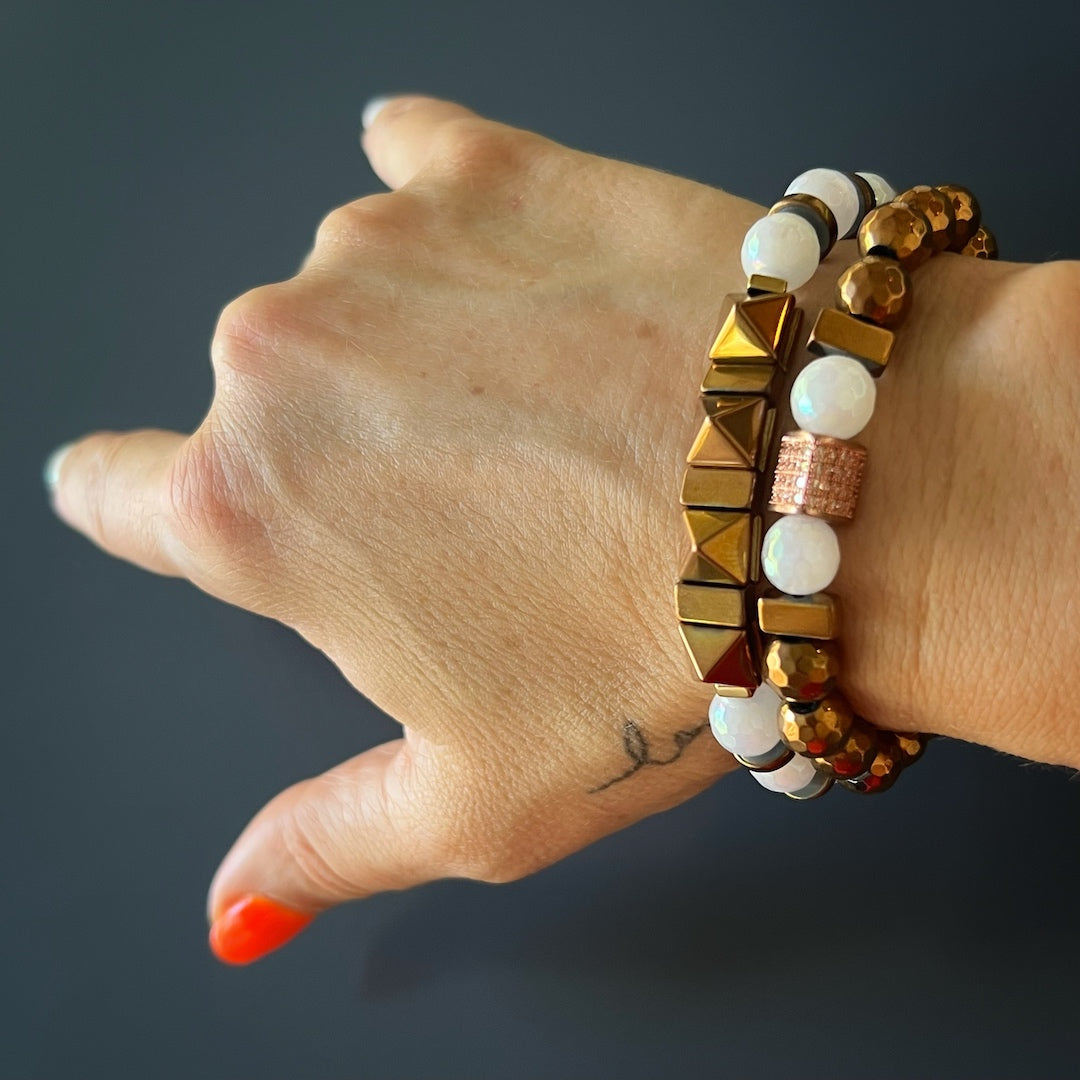 See the Rose Energy Quartz Bracelet Set gracefully adorning the hand model's wrist, showcasing the beauty of rose gold hematite and quartz stones.