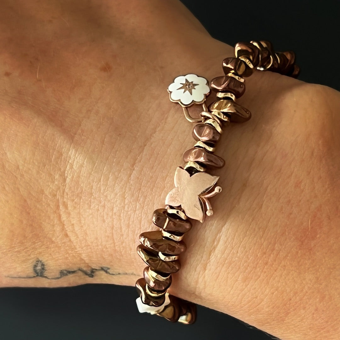 The hand model gracefully wears the Rose Energy Spring Bracelet, showcasing the elegance of rose gold hematite beads and delicate silver charms.