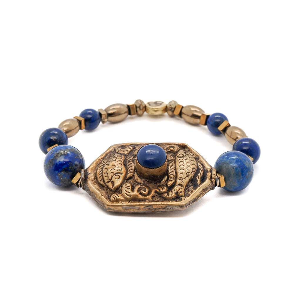 Discover the beauty of the Samsara Bracelet, featuring Lapis Lazuli stone beads and a Nepal handmade Golden Fish charm.