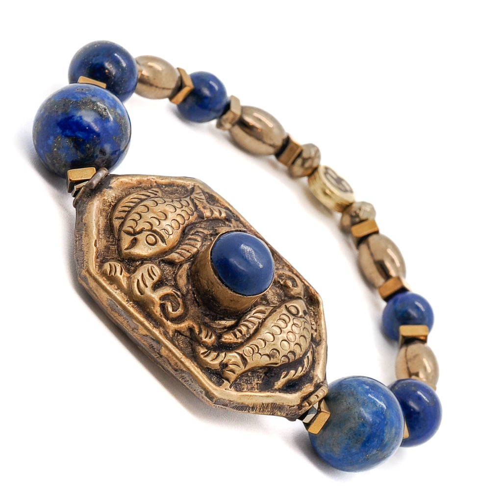 Adorn your wrist with the elegant Samsara Bracelet, a vintage-style piece with Lapis Lazuli stone beads and a symbolic Golden Fish charm.