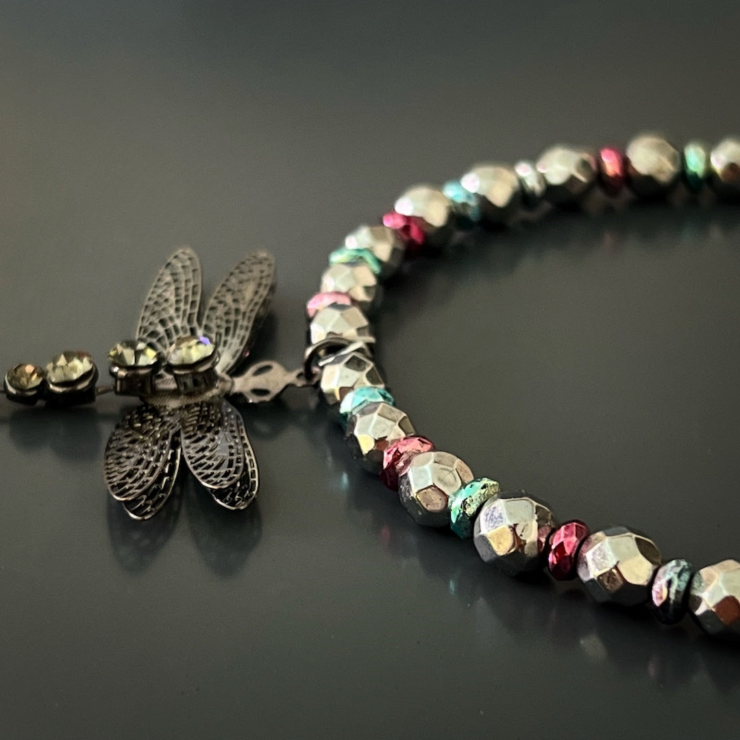 Elevate your style and embrace self-love with the Self Love Dragonfly Anklet, featuring silver hematite stone beads, blue and pink hematite spacers, and a silver dragonfly charm that symbolizes personal growth and the beauty of embracing one&#39;s true self.