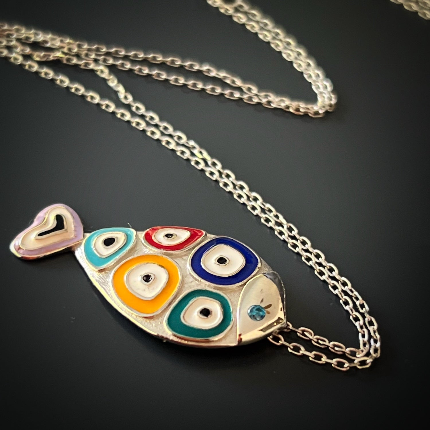 The captivating Silver Evil Eye Fish Necklace, designed to attract positive energy and add a touch of charm to your everyday look.
